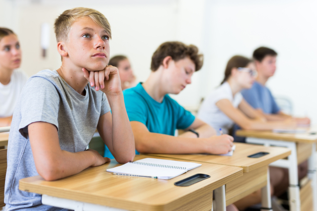 Teenager,Students,Sitting,At,Desks,And,Listening.,Boy,Sitting,In