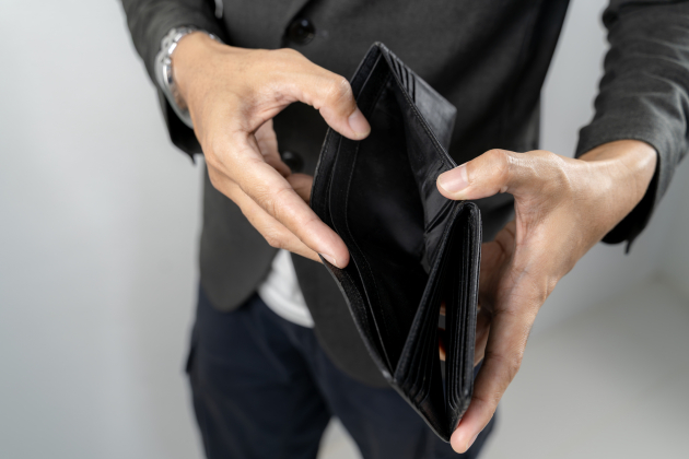Man showing empty leather wallet with no money inside